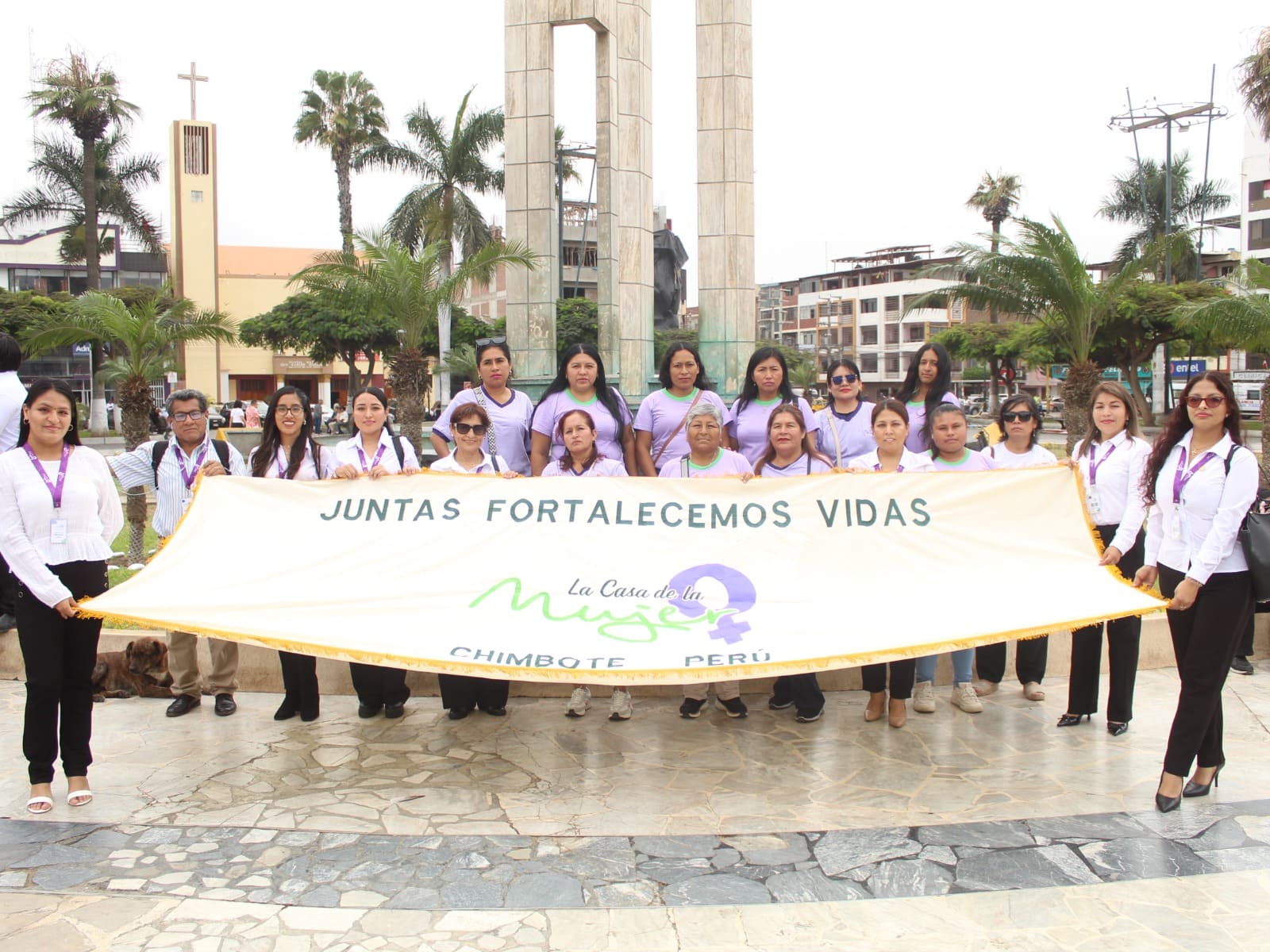 Equipo de La Casa de la Mujer sosteniendo una banderola institucional